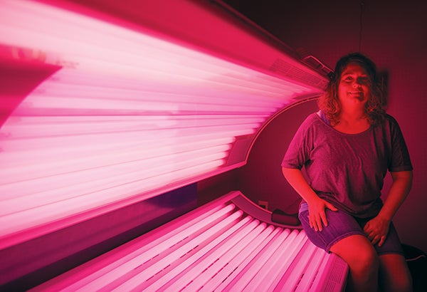 Jody Davis, owner of Etc. Tanning in Albert Lea, sits on the edge of one of the tanning beds that’s been switched over for use in red-light therapy treatments. – Colleen Harrison/Albert Lea Tribune 