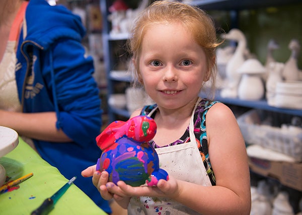 Kaylee Dimmel, 5, shows off a rabbit she painted Friday during Paint Till You Faint at Country Charm Ceramics as part of Ellendale Days. — Colleen Harrison/Albert Lea Tribune