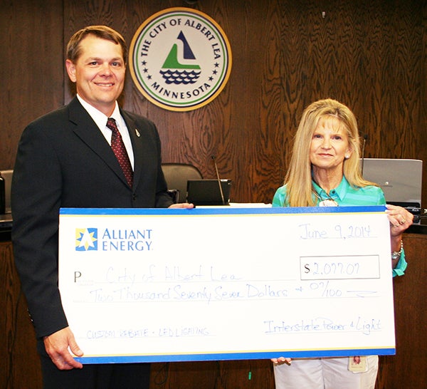At the June 9 council meeting, Rebecca Gisel, right, of Alliant Energy presented a rebate check to the City of Albert Lea and Mayor Vern Rasmussen, Jr. in the amount of $2,077.07 for the lighting upgrade at the City Garage. The rebate will pay for 25 percent of the LED lighting installed and will also provide an annual reduction of over $1,000 in electric costs to the city. – Provided