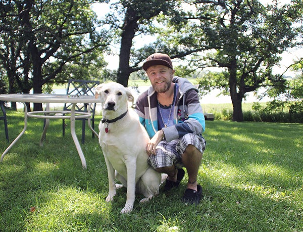 Bob Culbertson sits in his backyard with his dog, White Chocolate, in rural Albert Lea earlier this week. – Erin Murtaugh/Albert Lea Tribune