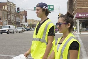 Dawson Luttrell, left, and Mitzi Soto help collect donations on the intersection of Broadway Avenue and Main Street for the Freeborn County Humane Society on Friday. – Hannah Dillon/Albert Lea Tribune