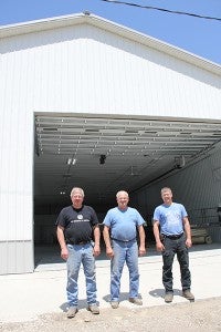 Lamoyne Krohnberg stands between his two sons, Stacy, on the left, and Brady, on Wednesday. They are in front of the new building for their business, Krohnberg’s Garage. The building replaces the Walters Creamery and greatly changes the landscape of Main Street in Walters. – Tim Engstrom/Albert Lea Tribune