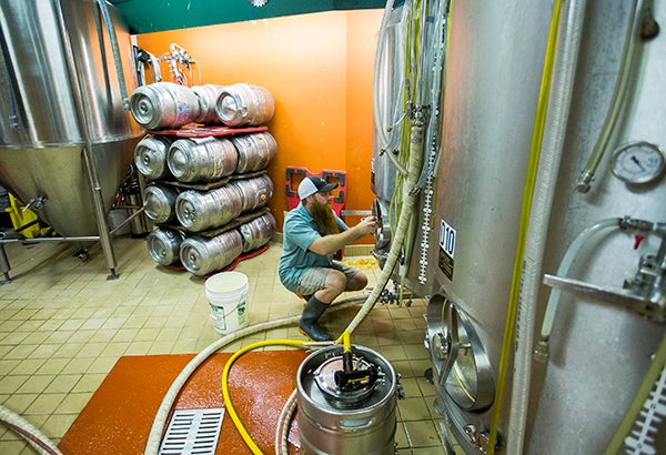Bjorn Erickson, brewer at Fitger’s Brewhouse, cleans out a tank July 11 at Fitger’s Brewhouse in Duluth. – Minnesota Public Radio News