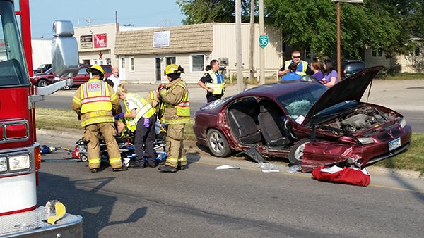 Firefighters, paramedics and police officers assist with the extrication of a person from a car following a crash Friday on East Main Street in Albert Lea. — Tim Engstrom/Albert Lea Tribune