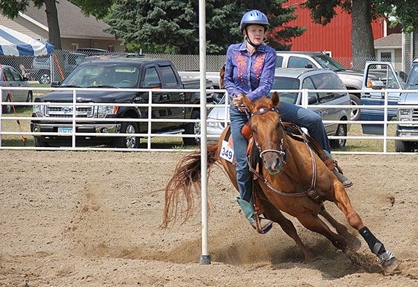 Makayla Fennegan and her horse lean into the end pole Friday at the Freeborn County Fair. Many riders in pole weaving say the skills needed to turn around the end pole is their favorite part. — Tim Engstrom/Albert Lea Tribune