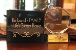 A plaque which reads “The love of a family is life’s greatest blessing,” along with an inspirational award DuWayne Kirchner won as a 1992 attendee to an Alpha-1 group are displayed in his home. – Erin Murtaugh/Albert Lea Tribune