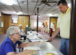 Neva Mathison hands Brian Hensley a ballot Tuesday at First Baptist Church in Albert Lea. – Sarah Stultz/Albert Lea Tribune