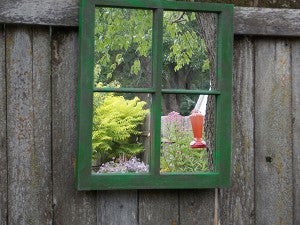 Lang added a mirror to the back of a window frame after taking out the glass to extend the view of the gardens. It makes it look like you are seeing more of the gardens through the window when you are actually seeing a reflection of the garden in front of the mirrored window. – Carol Hegel Lang/Albert Lea Tribune