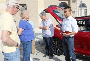 Greg and Alice Iverson of Clear Lake listen to a Tesla Motors representative talk about their electric cars Wednesday in front of ISC Financial Advisors. – Sarah Stultz/Albert Lea Tribune