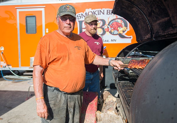 Gordy Jensen, left, and his son Bruce prepare ribs Friday before the start of the Big Island Bar-B-Que at the Freeborn County Fairgrounds. Bruce and his brother, Rich, run Smokin' Bros BBQ out of Albert Lea and have been competing for six years. — Colleen Harrison/Albert Lea Tribune