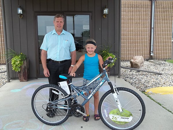 Hope Nielsen, age 8, pictured above with the Rev. Clayton Balsley, was the winner of the bike drawing held at the Calvary Baptist/First Baptist Church booth at the Freeborn County Fair. The bike drawing, sponsored by the Awana program, has been held each year at the church fair booth. Awana is a Bible-based, nondenominational kids program that is held at Calvary Baptist Church, 2016 Bridge Ave. in Albert Lea from 6:30 to 8 p.m. each Wednesday. To register children for the program a BBQ registration kickoff for the 2014-2015 season will be at 6 p.m. Wednesday for kids and their families. – Provided