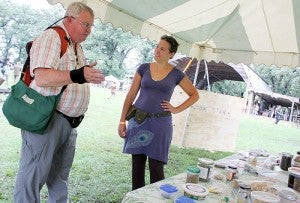 Marisha Auerbach, of Portland, Ore., right, talks with Lee Barnes, of North Carolina, on Friday at a seed exchange at  Harmony Park during the North Americasn Permaculture Convergence.  — Sarah Stultz/Albert Lea Tribune