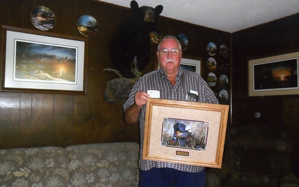 Darrell Wolff of Albert Lea won a Jim Hansel print from the Freeborn County Pheasant and Habitat booth at the Freeborn County Fair. He’s holding a membership card from 1973, when the organization began. – Provided