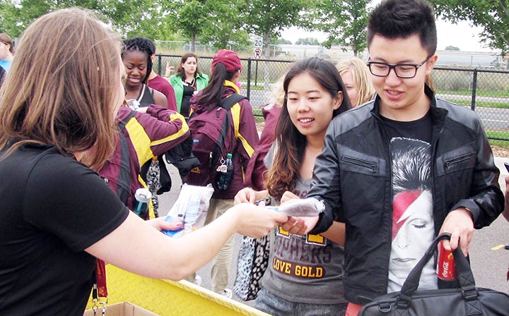 A University of Minnesota staffer hands out ice cream treats to transfer students at a tailgating event next to TCF Bank Stadium before the Gophers’ game against Eastern Illinois on Aug. 28. – Alex Friedrich/MPR News