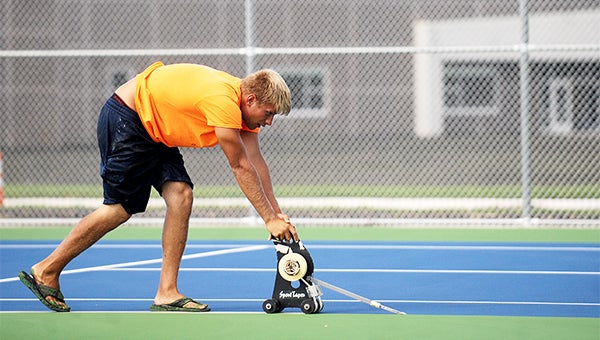 Jesse Langmade of Upper Midwest Athletic Construction from Anoka uses a tape machine to mark the lines on the tennis courts Wednesday at United South Central. The courts will be used on Saturday. — Micah Bader/Albert Lea Tribune