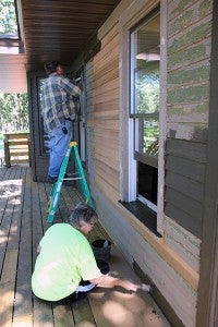 Sandy Stephens, front, and Lyle Hinz paint the exterior of the Edgewater Cottage Tuesday afternoon. – Sarah Stultz/Albert Lea Tribune