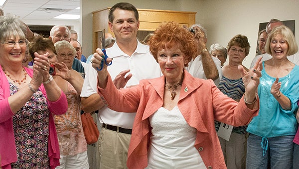 Albert Lea native Marion Ross, an actress known for her role as Mrs. C on “Happy Days,” raises her hands in the air after cutting a ribbon in the new Marion Ross exhibit at the Freeborn County Historical Museum in July 2013. –Sarah Stultz/Albert Lea Tribune