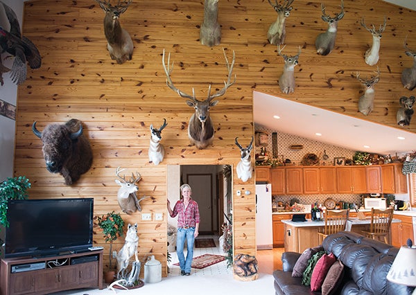 Angie Stickfort stands in the living room of her Albert Lea home, decorated in multiple trophies from hunting trips she and her husband, Craig, have gone on.