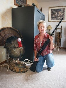 Stickfort poses next to one of her trophies. She hunts turkeys with  a 12-gauge shotgun.