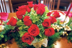 A poinsettia, Christmas cactus or red roses make a beautiful centerpiece for a holiday dinner table. 