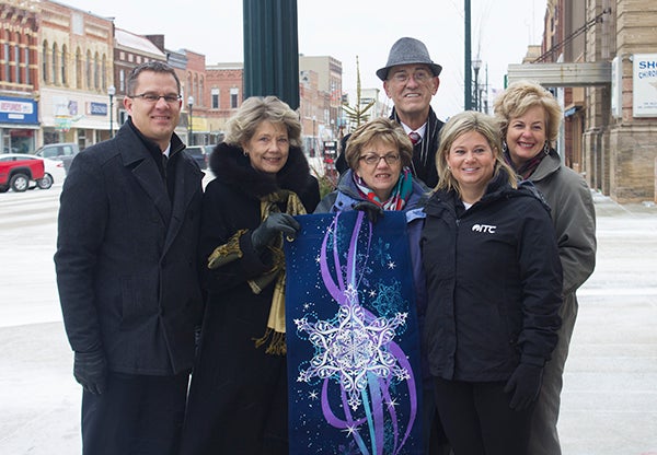 From lFrom left, Albert Lea City Manager Chad Adams, Beth Ordalen, Tami Staker, Albert Lea-Freeborn County Chamber of Commerce Director Randy Kehr, ITC Midwest Area Manager of Local Government and Community Affairs Lori Broghammer and Albert Lea Convention and Visitors Bureau Director Susie Petersen stand around one of the new holiday banners to decorate the downtown that were purcahsed as part of a collaboration. – Sarah Stultz/Albert Lea Tribune