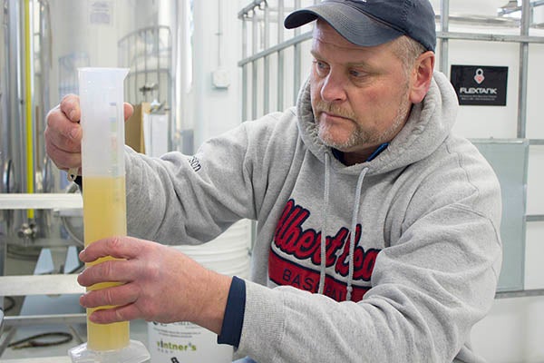When fermenting wine, the yeast eats the sugar in the juice then turns it into alcohol. Toward the end of the fermentation process, Three Oak Wines owner Jay Enderson checks the wine every day to look at the sugar content. – Hannah Dillon/Albert Lea Tribune