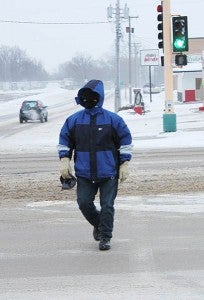 Joseph Madrigal crosses West Main Street at the First Avenue intersection Jan. 16, heading north. Covering the face made the difference when heading into the strong northwest wind. – Tim Engstrom/Albert Lea Tribune