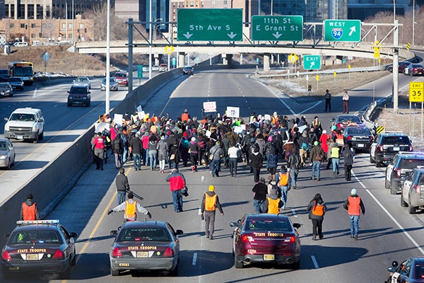 A group protesting a New York grand jury’s decision not to indicit a police officer in the death of Eric Garner walk toward downtown Minneapolis after crossing under the Franklin Street bridge on Thursday. – Jennifer Simonson/MPR News