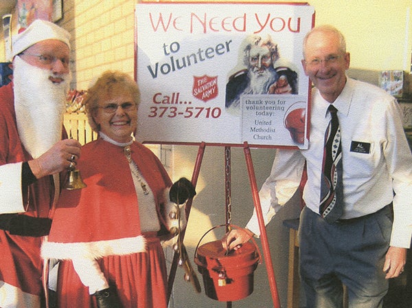 Albert Lea Hy-Vee Manager Al Wiesert, right, donates to the Salvation Army’s red kettle drive, along with Doug and Patty Christopherson, dressed as Santa and Mrs. Claus. – Provided