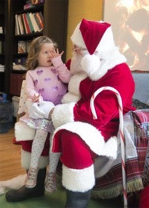 Quinn Olson tells Santa Claus that she's 4 years old Dec. 12 during a visit at Brookside Education Center. — Colleen Harrison/Albert Lea Tribune