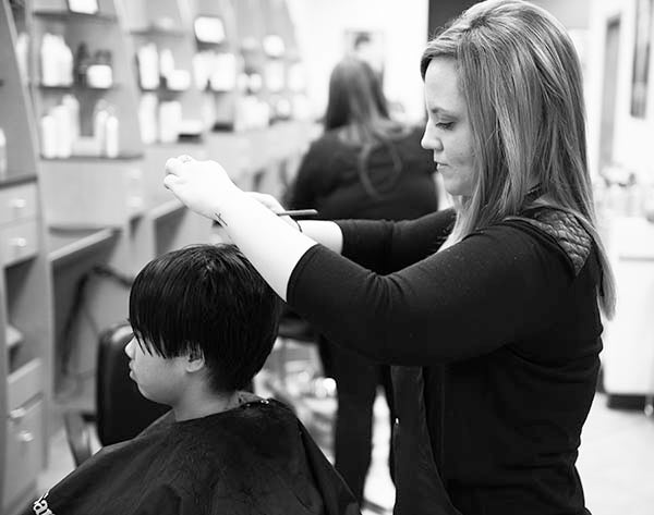 Hairstylist Amber Busall cuts Meridian Fiscus’ hair at Fantastic Sams Hair Salon in Albert Lea.