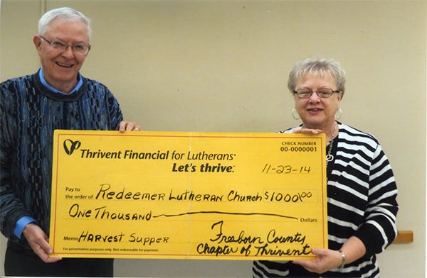 Virginia Boettcher, representing Redeemer Lutheran Church, accepts a check from Neil Pierce of the Freeborn County chapter of Thrivent Financial. The check for $1,000 is supplemental funding for the fall harvest dinner Oct. 19. The moeny raised, plus the supplemental funding, will go toward paying for the landscaping project on the east side of Redeemer Lutheran Church. — Provided