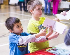 Students ask to have their passports stamped at the Festival of Nations Thursday at Hollandale Christian School. — Colleen Harrison/Albert Lea Tribune