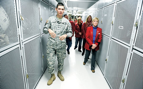 Sgt. Caleb Oberg leads a group of the Austin Chamber Ambassadors through the remodeled personal storage area in the basement of the Austin National Guard Armory Tuesday afternoon. - Eric Johnson/Albert Lea Tribune