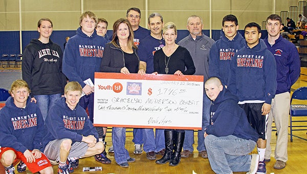 A check was presented from the Albert Lea wrestling team, the Albert Lea Wrestling Booster Club and Youth 1st to the Gracelyn Andersen Benefit Fund. More than 300 T-shirts were sold, which raised $1,746. Front row from left are Devin Nelson, Beau Johnsrud and Dominick Fadden. Back row from left are Albert Lea athletic director Afton Wacholz, Trison Westerlund, Tim Christianson, Ann Glazier and Brad Nelson of the Albert Lea Wrestling Booster Club, Mark Arjes of Youth 1st, Sue Andersen, Albert Lea wrestling coach Larry Goodnature, Dereck Samudio, Santana Acosta, and assistant coach Paul Durbahn. — Pam Nelson/For the Albert Lea Tribune