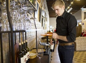 Patrick Hanson, co-owner and manager of Prairie Wind Coffee prepares to open a bottle of wine on Feb. 6. Prairie Wind Coffee is now known as The Interchange Wine & Coffee Bistro, and is Albert Lea’s first Blue Zones restaurant. - Sarah Stultz/Albert Lea Tribune