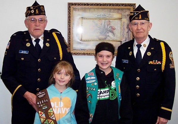 Girl Scouts Shelby and Marissa Hanson, pictured with Bill Goette and Dave Olson, deliver cookies to veterans. The girls will collect donations to fund their project until March 29. - Provided