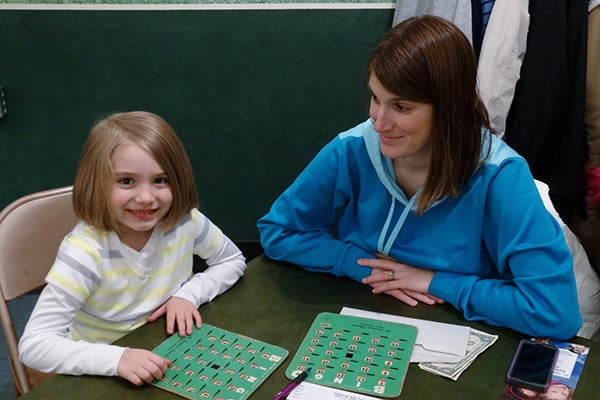 Kylee Koziolek and her mother, Kristi, watch their (hopefully) winning Bingo boards closely. - Provided