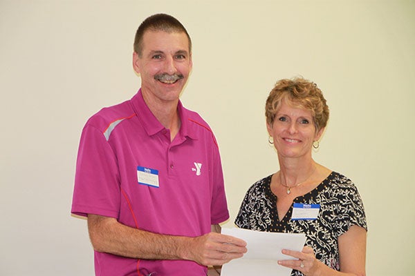 Dennis Dieser, executive director of the Albert Lea YMCA, accepts a donation from Jillian Peterson, board chairwoman of the Freeborn County Community Foundation. - Provided