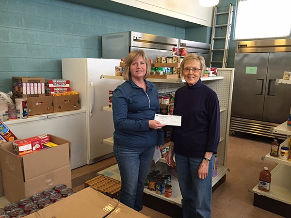 Cindy Farr delivers a check and food to Dorothy Simonsen of the Ecumenical Food Pantry in Albert Lea. The donations are from Innovance employees who collected 285 pounds of food and raised $1,000 during their March Food Drive. -Provided
