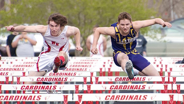 Grant Boehmer of Lake Mills, right, leaps over a hurdle Tuesday at Garner-Hayfield/Ventura. Boehmer took sixth place in the 110-meter hurdles with a time of 18 seconds. The Lake Mills boys’ track and field team took third place out of 12 teams with 82 points. — Lory Groe/For the Albert Lea Tribune