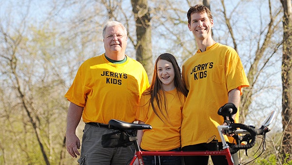 Chris Utz, right, his daughter, Erin, and father, Jerry, stand behind Chris’ 1985 steel-frame seven-speed Trek Elance on April 27 at a trailhead west of Brookside Education Center. — Micah Bader/Albert Lea Tribune