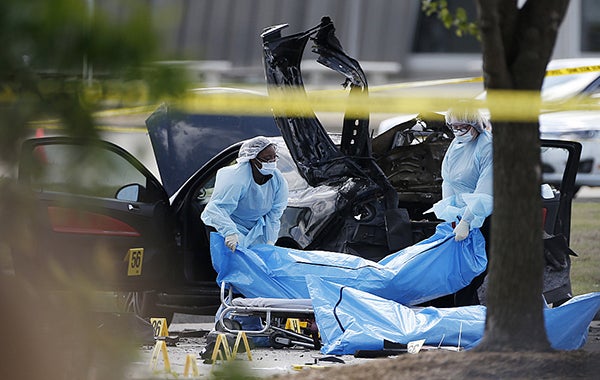 Personnel remove the bodies of two gunmen Monday in Garland, Texas. Police shot and killed the men after they opened fire on a security officer outside the suburban Dallas venue, which was hosting provocative contest for Prophet Muhammad cartoons Sunday night, authorities said. Brandon Wade/AP