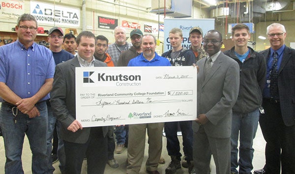 Knutson Construction, with an office in Rochester, recently presented a check to Riverland Community College to support a carpentry scholarship and equipment to assist students. Pictured left to right are Walt Alms, carpentry instructor; Brenden Chadwick, Jorge Alejo-Rubio, carpentry students; Tom Leimer, general manager Knutson Construction; Eduardo Vega, Mark Paddock, Zack Smith, carpentry students; Matt Bissonette, Riverland dean of business, technology, trade and industry; Bryer Kruse, Jared Bingham, carpentry students; Dr. Adenuga Atewologun, Riverland president, Wyatt Blum, carpentry student; and Steve Bowron, Riverland dean for institutional development. - Provided