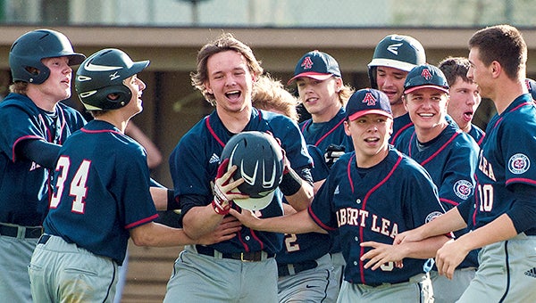 Chris Enderson of Albert Lea, middle, celebrates with his teammates after hitting a walk-off home run in the bottom of the seventh inning to complete a comeback and win Game 1 of a doubleheader. — Micah Bader/Albert Lea Tribune