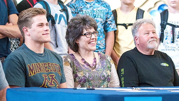 Tim Christianson, left, sits with his mother, Kim, and his father, Tim, before signing his national letter of intent to wrestle for the Minnesota Gophers Thursday at Albert Lea High School. — Micah Bader/Albert Lea Tribune