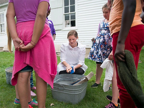 Freeborn County fifth graders learn how pioneers washed their clothes during Discover History Thursday at the Freeborn County Historical Museum. Albert Lea High School juniors were on hand to teach the students. — Colleen Harrison/Albert Lea Tribune
