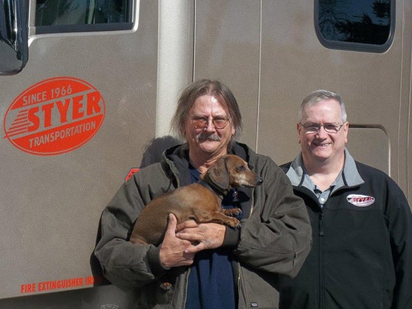 Styker Transportation Company of Lakeville recognizes Larry Drescher for driving three million accident-free miles. Drescher is pictured above holding his travel companion, Timmy, alongside Styker Transportation Safety Director Owen Ivey. - Provided