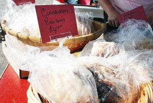 Jennifer Lomack of Austin sells several varieties of artisan bread, including cinnamon raisin and garlic tomato basil. - Tribune file photo