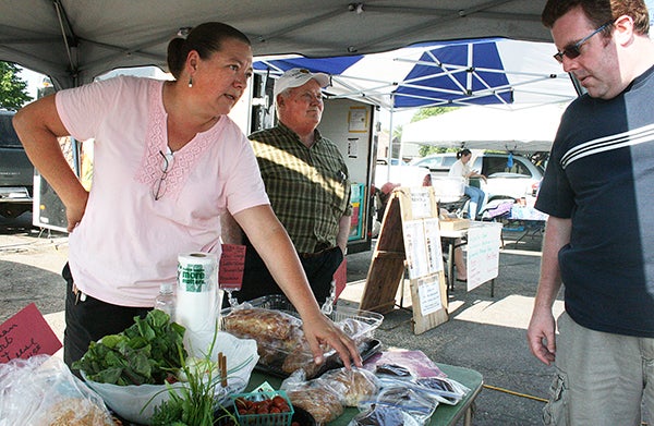 Austin woman Jennifer Lomack, left,  talks with Seattle resident Chris Campbell in July 2012 at the Albert Lea Farmers Market about some of the gluten-free items she sells at the market. - Tribune file photo